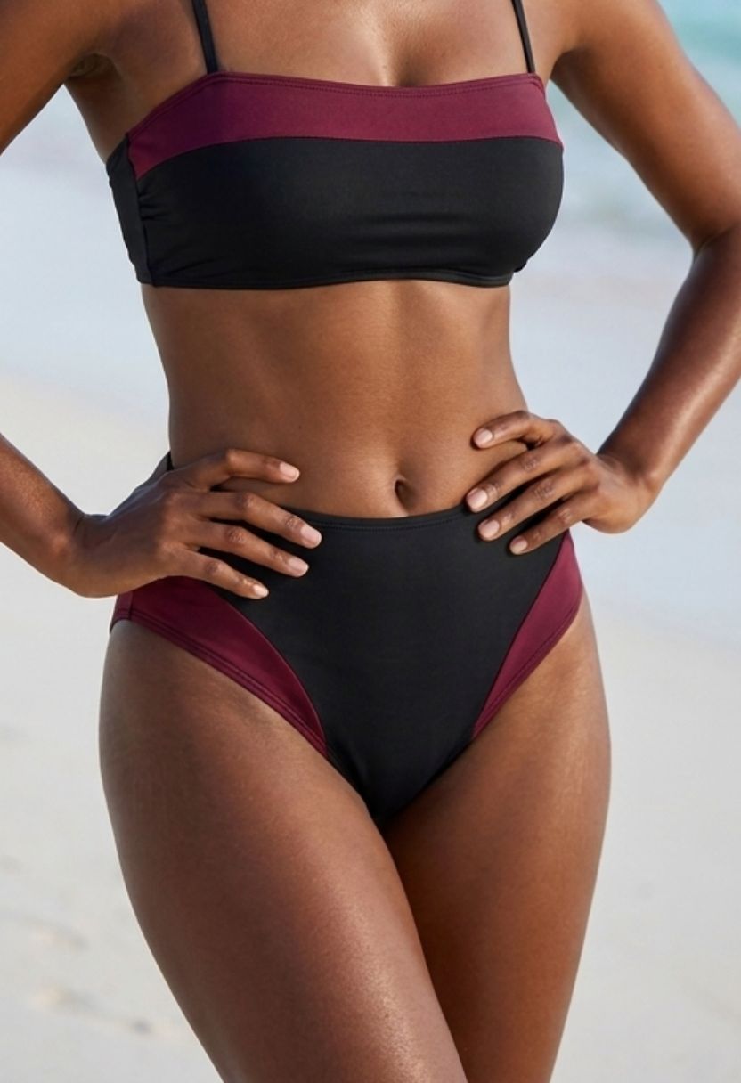 Sofia black high-waist bikini bottom with burgundy side panel on model, close-up front view
